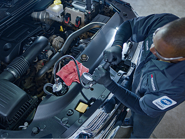 Bird's eye view of technician working under the good of a car.