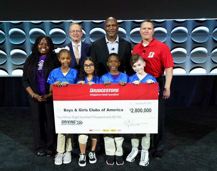 Boys & Girls Club of America receiving big donation check from Bridgestone staff