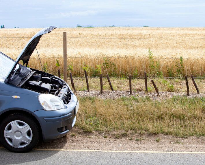 Blue car with hood open, broken down on country road