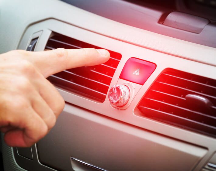Hand reaching for car's hazard light button on center console