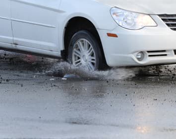 Car Passenger Tire Running Over Pothole