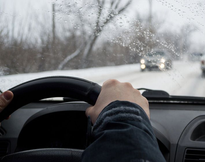 Driver with two hands on the wheel on a snowy road