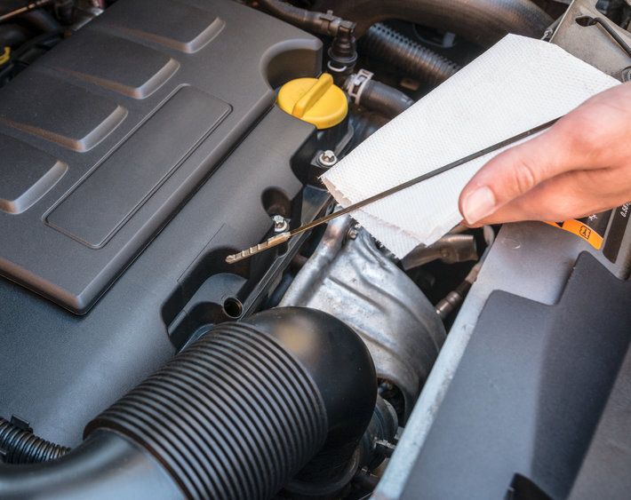 Oil level check in a car engine by verifying the dipstick