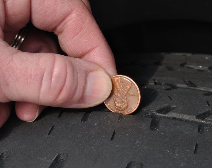 Testing tire tread depth with a penny