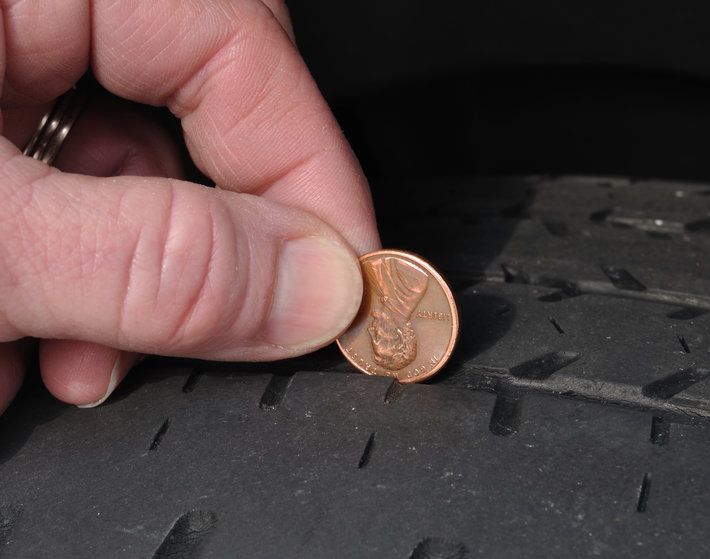 Inspecting The Wear Of A Balding Tire Tread Using a Penny