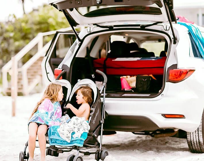 Children in stroller in front of car