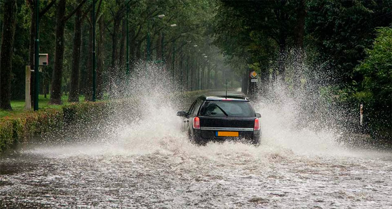 parte trasera de una camioneta con llantas antiderrapantes que avanza levantando agua