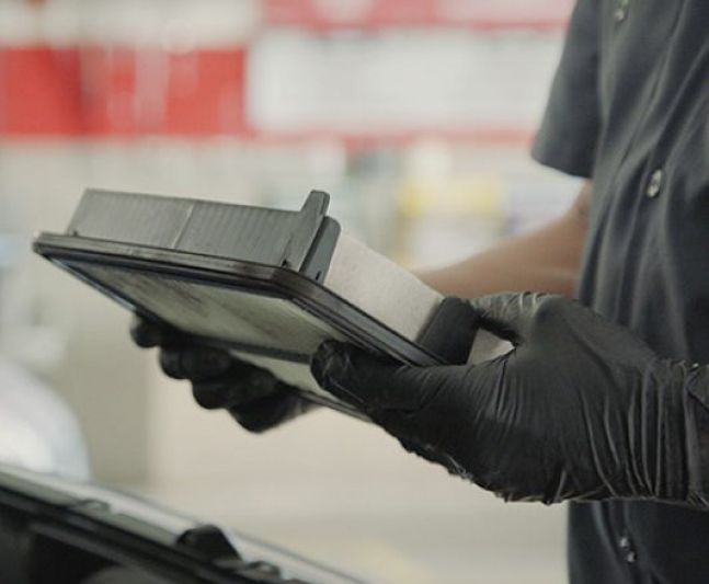 A close-up of a car cabin filter being examined.