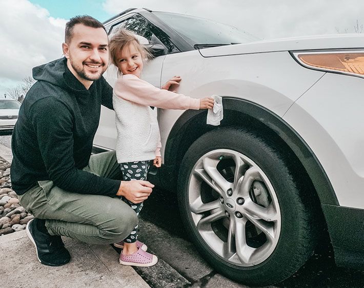 daughter helping her dad clean the car