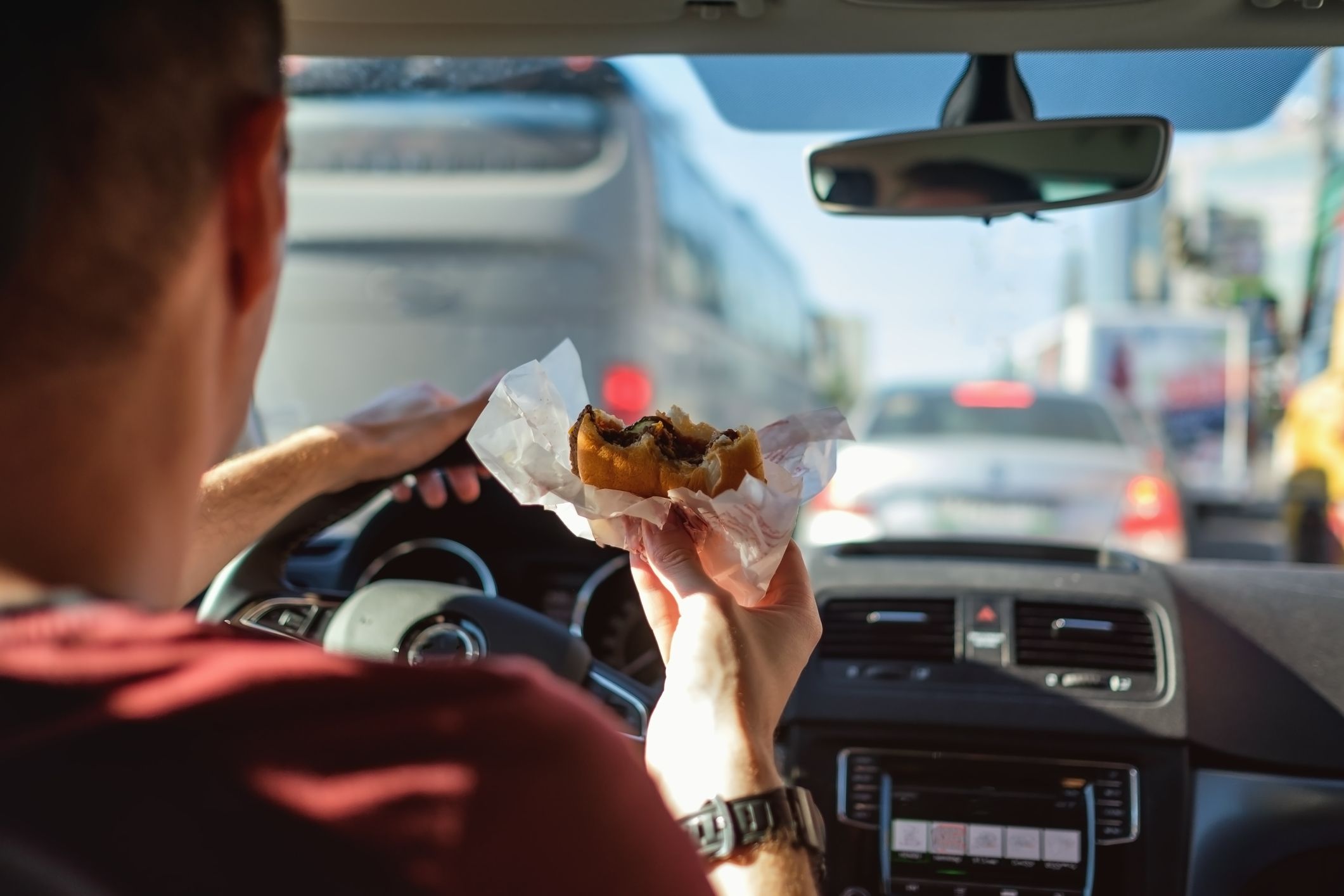 Image of a man eating while driving