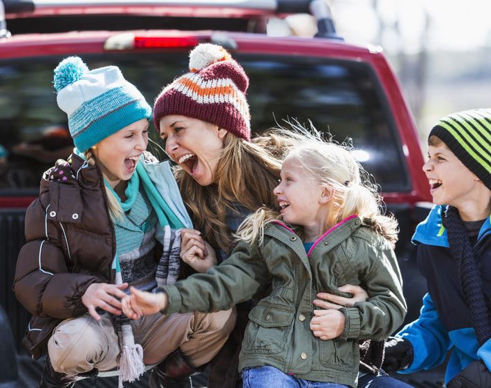 Family sitting in pickup truck bed