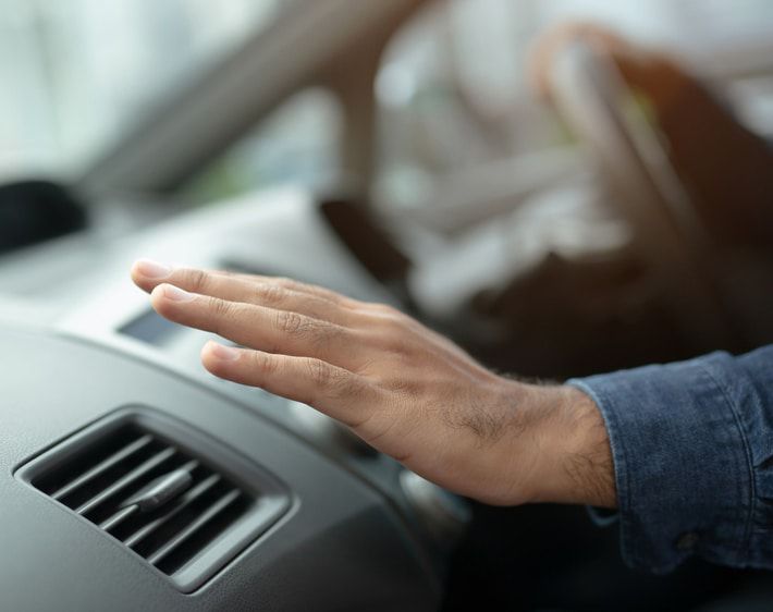 Person feeling air out of car vent