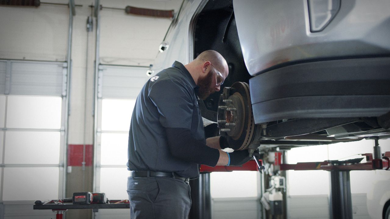 Firestone technician working on a brake pad