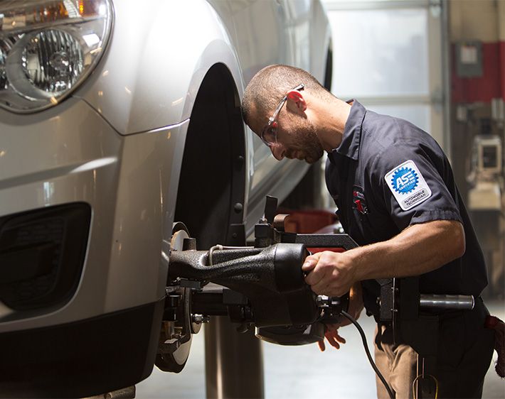 Professional technician repairing vehicle at Firestone Complete Auto Care