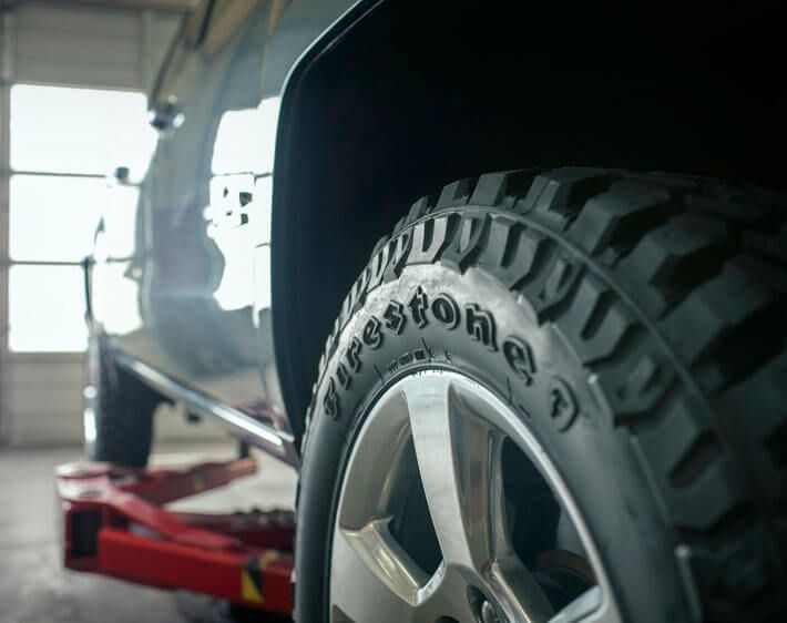 close up of back left Firestone truck tire in a garage