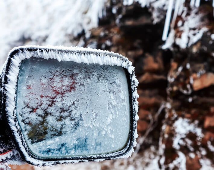 Frosted car mirror on cold winter morning