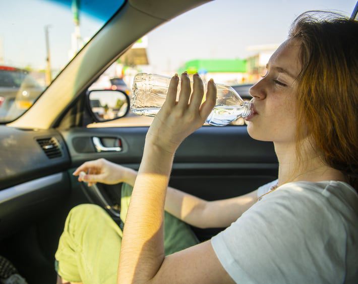 Girl drinking water in passenger seat