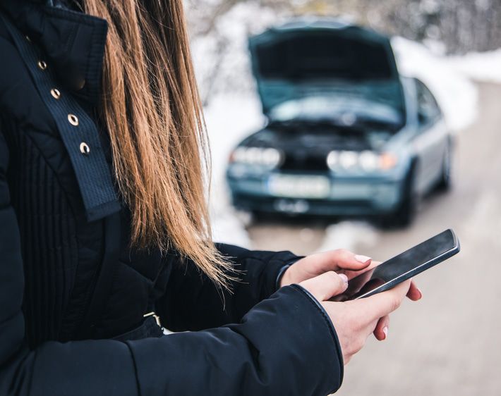 Girl on phone stranded on the side of the road