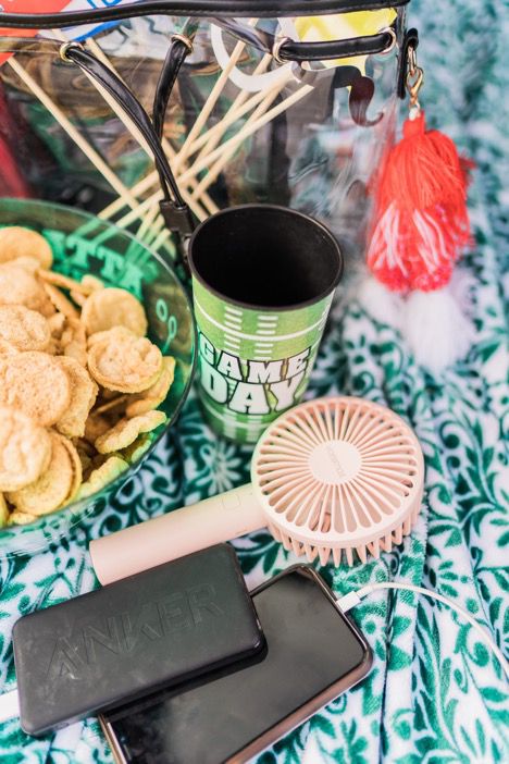 Portable fan next to snacks and phone charging