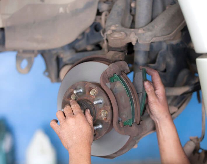 bear hands working on a brake pad