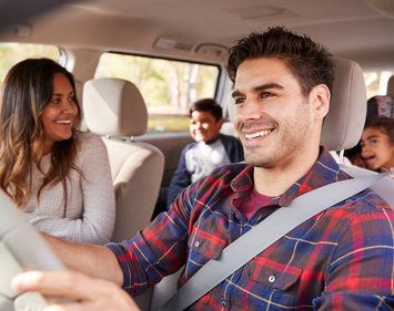 Mother turns around to her children in the back seat of car