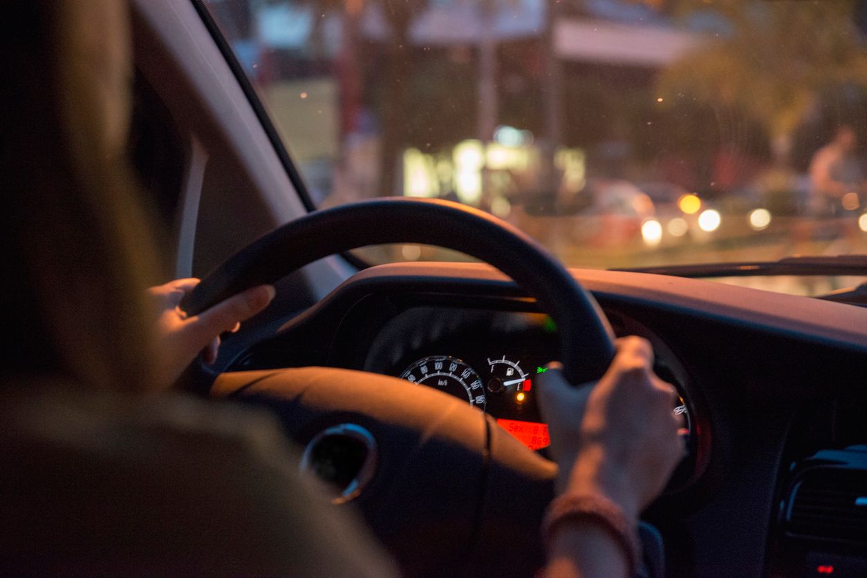 woman driving as low gas warning light turns on.