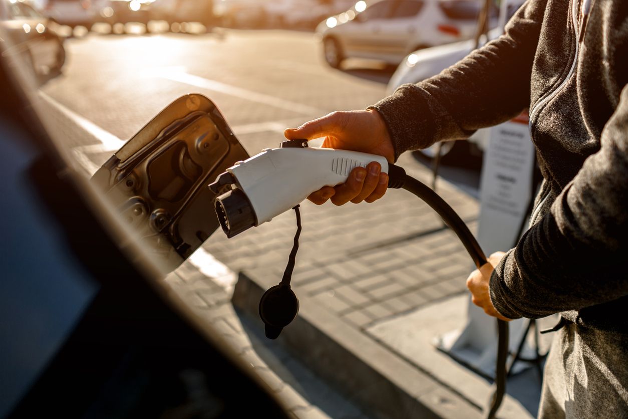 Man Holding Power Charging Cable For Electric Car