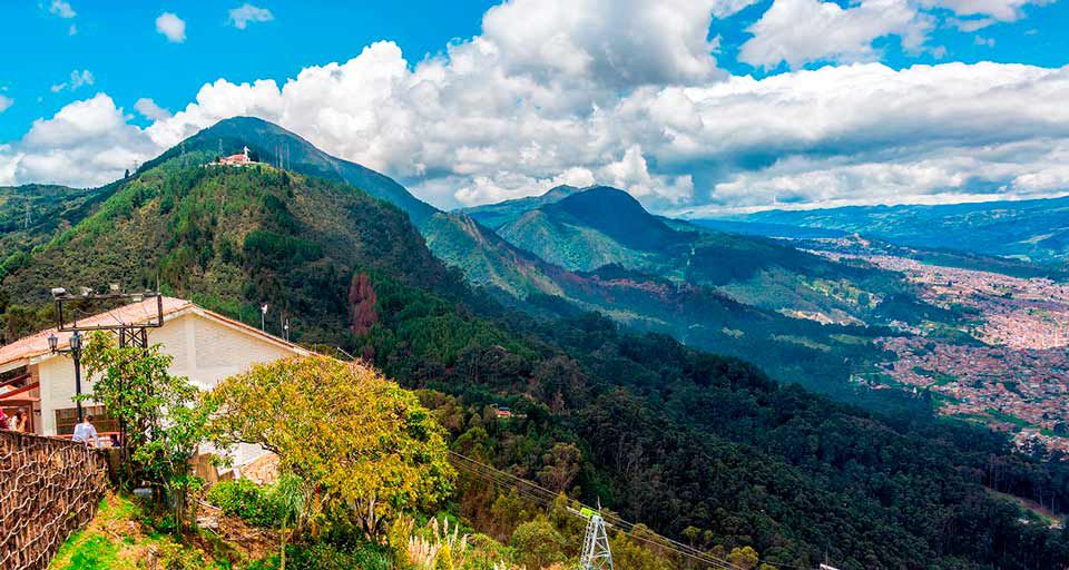 Paisaje de montañas con pasto retratadas desde una casa en la colina