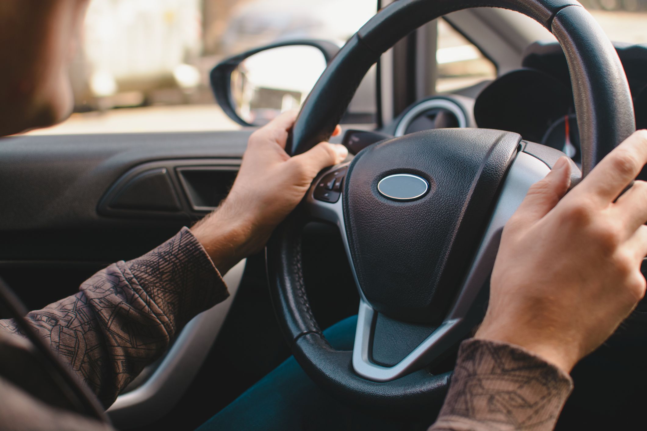Person in car holding steering wheel