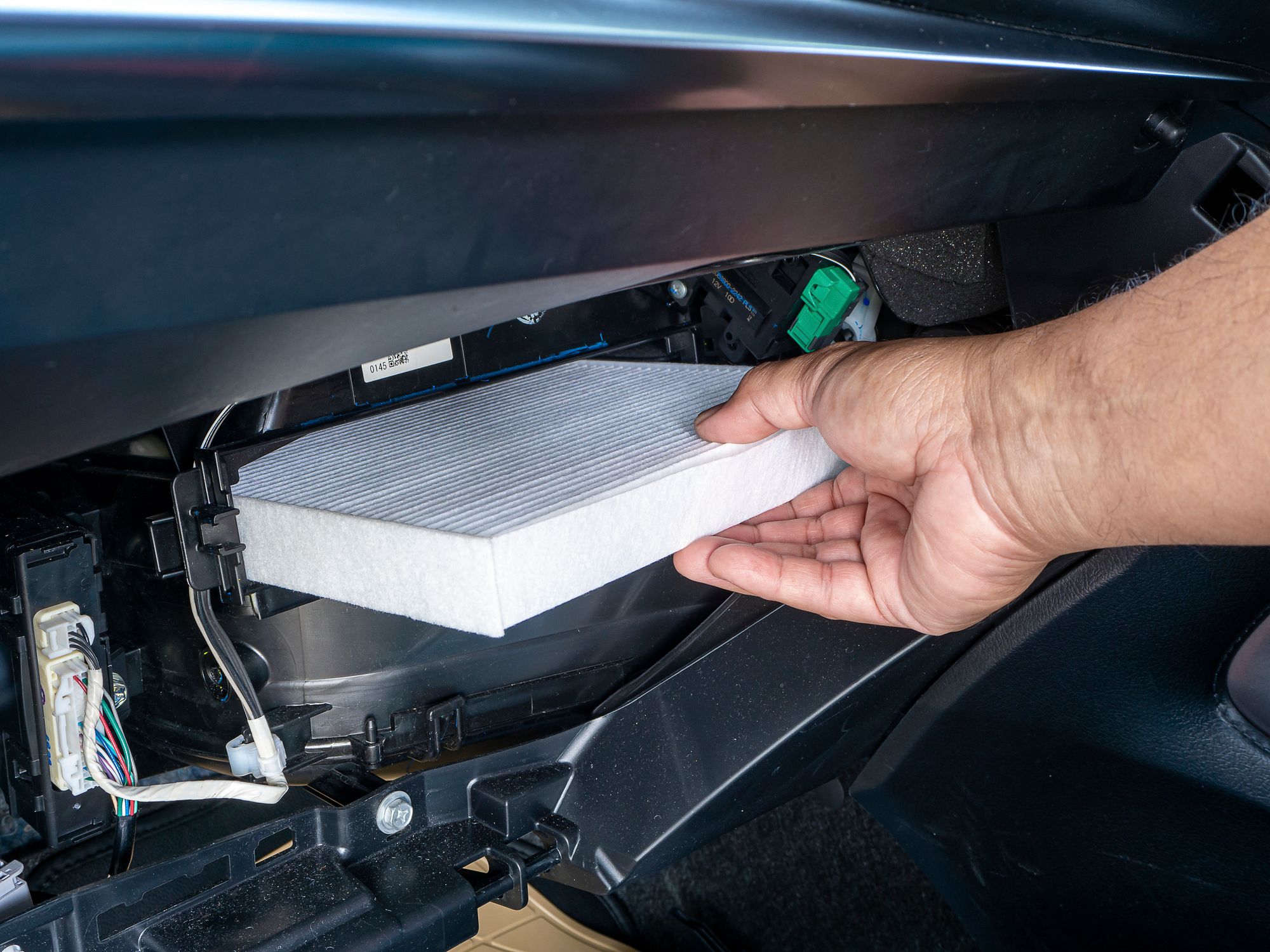 Hand replacing a car air filter