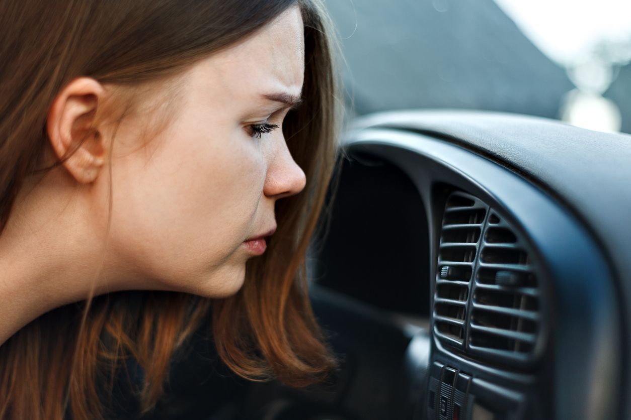 Woman smelling a bad smell coming from the A/C