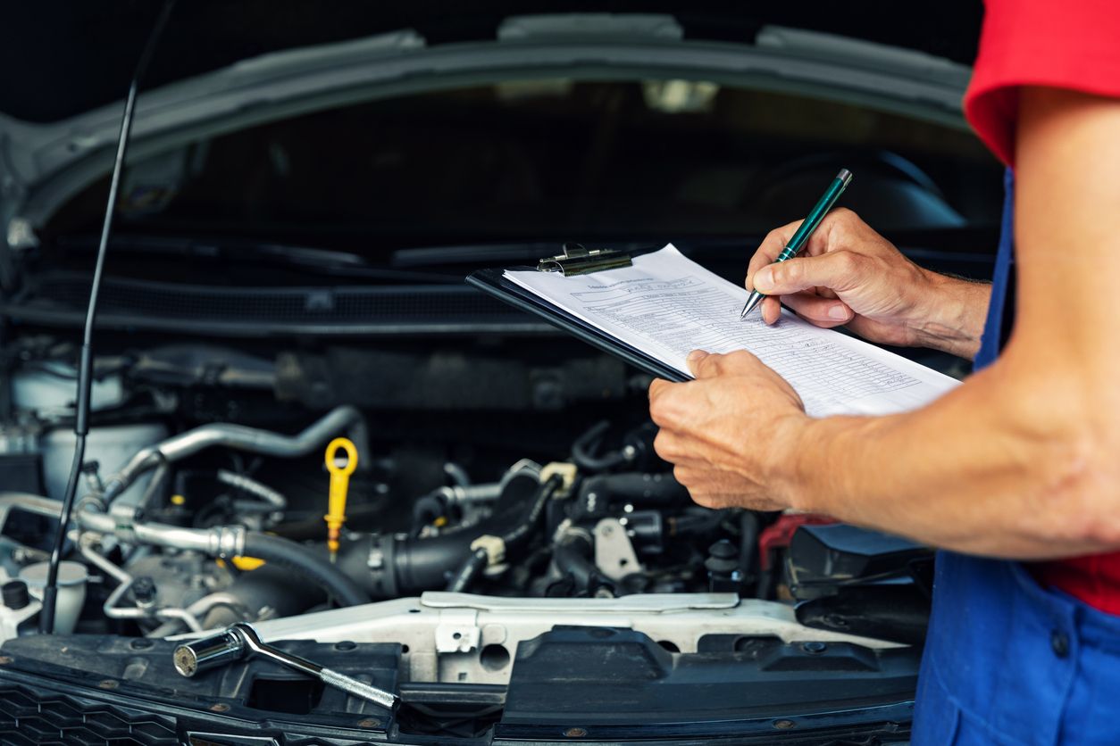 car maintenance and repair - mechanic writing checklist paper