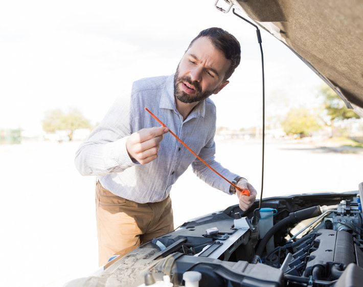 Man checking oil dipstick