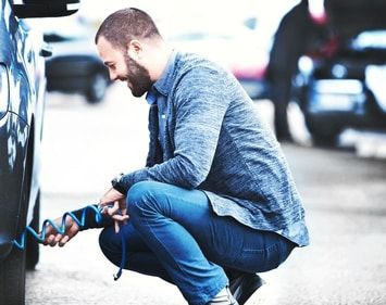 Man inflating his tires with gas station air machine