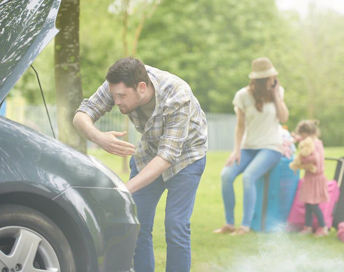 Man fanning a smoking car engine