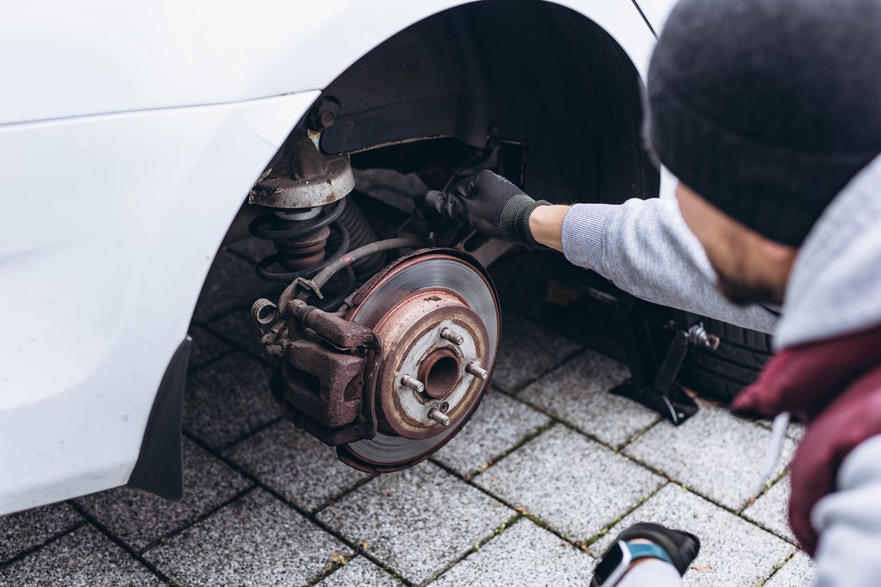 Man checking the wear on vehicle brakes