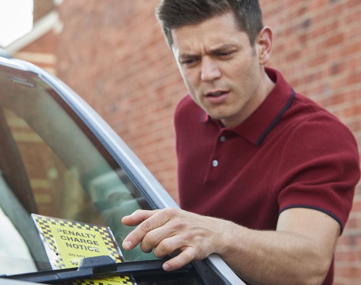 Man looking confused by parking ticket