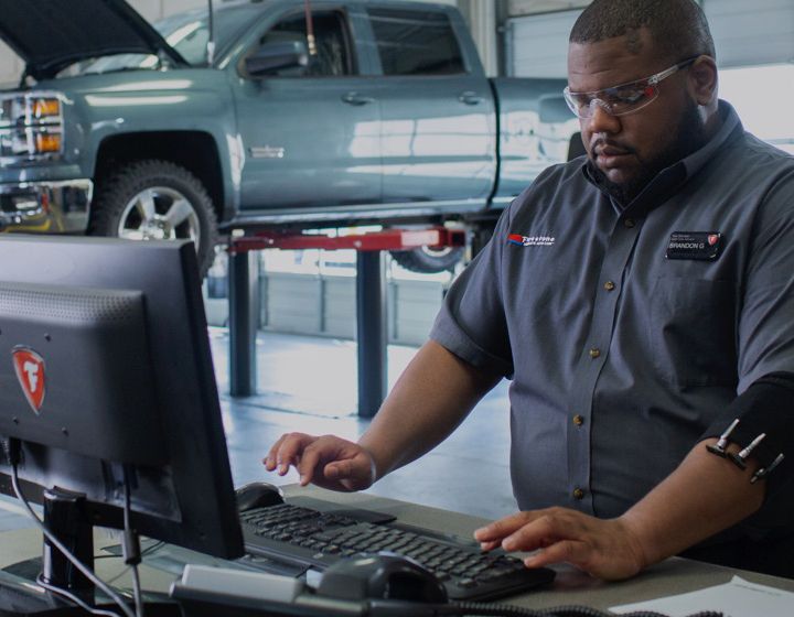 Firestone technician helping a customer book an appointment