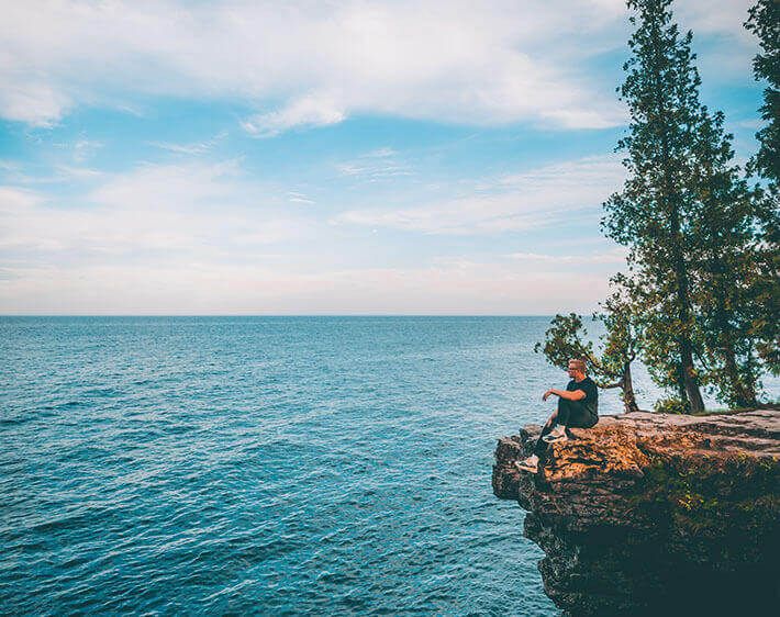 Man overlooking ocean from a cliff