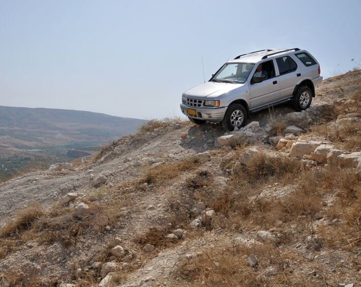 Silver SUV off-roading in mountainous, dry climate