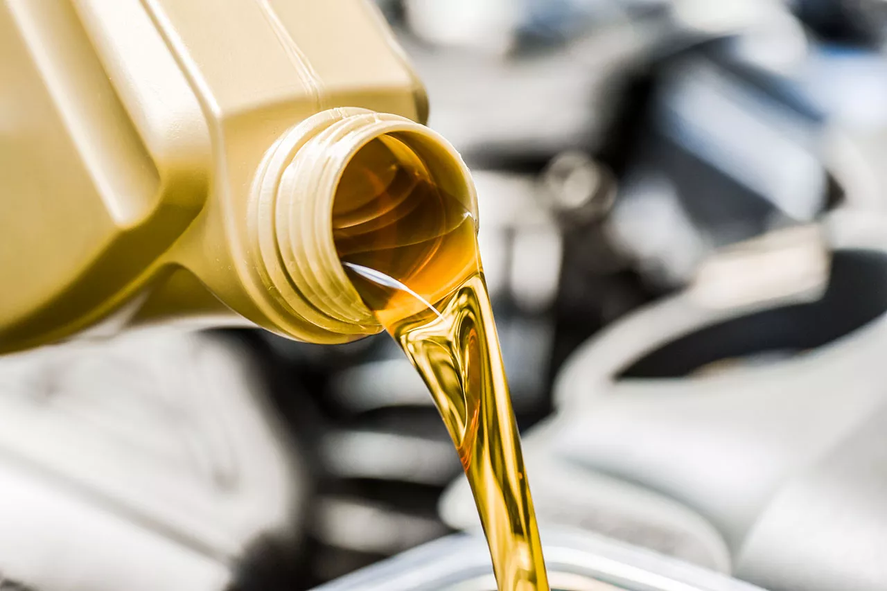Motor oil being poured into a vehicle engine.