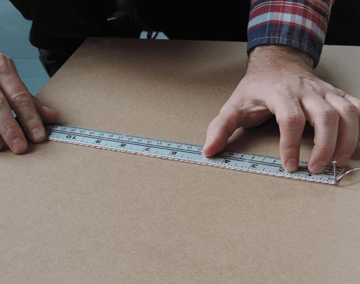 Measuring piece of plywood to place in center of old tire for used tire project