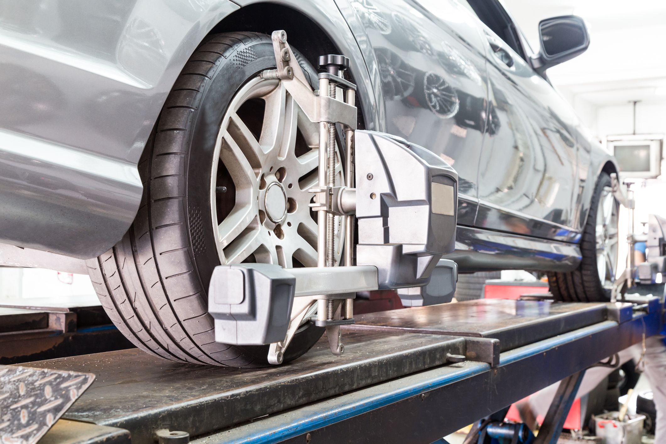 Closeup of tire clamped with aligner undergoing auto wheel align