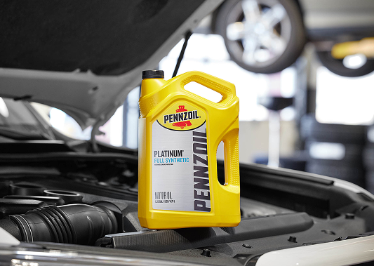 A container of Platinum Pennzoil full synthetic set on the hood of a car.