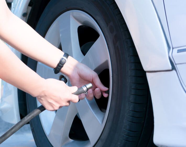 Person inflating a tire with air