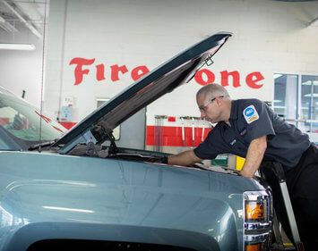 Firestone technician George checks engine under the hood