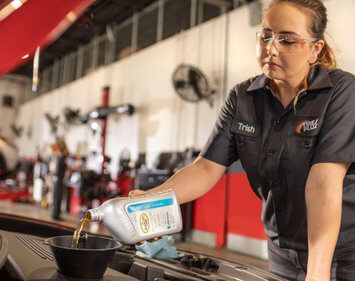 tires plus technician Trish performing an oil change