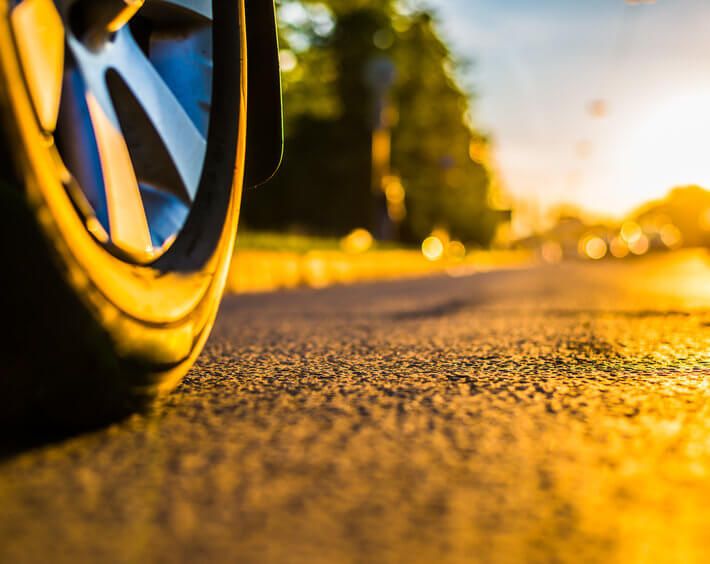 Tire on hot summer pavement, headed into the sunset