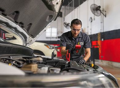 A technician testing a car battery.