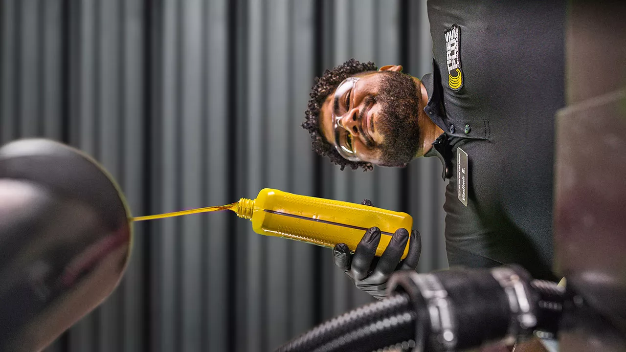 Motor oil being poured into a vehicle engine.